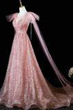 Pink sequin evening gown with a sheer overlay on a black background