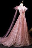 Pink sequin evening gown with a sheer overlay on a mannequin against a black background