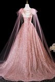 Pink glittery evening gown with a sheer cape on a black background