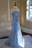 Light blue evening gown on a mannequin against a neutral wall.