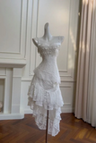 White lace dress on a mannequin against a neutral wall.