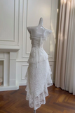 White lace dress on a mannequin against a neutral wall.
