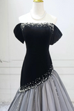 Black off-shoulder dress with silver embellishments on a mannequin against a white background