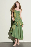 Woman wearing a green satin dress against a white background