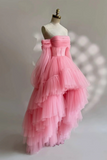 Pink ruffled gown on a mannequin against a neutral background