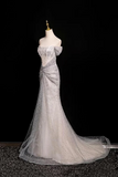 Silver evening gown on a mannequin against a black background