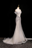 Silver evening gown on a mannequin against a black background
