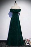 Green evening gown on a mannequin against a plain background