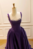 Purple evening gown on a mannequin against a neutral background