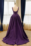 Purple evening gown on a mannequin against a window with blue curtains.