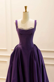 Purple evening gown on a mannequin against a beige background