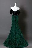 Green evening gown on a mannequin against a gray background