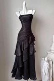 Black evening gown on a mannequin against a plain background