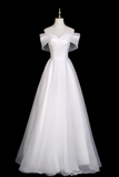 White off-shoulder gown on a mannequin against a black background