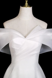 White dress with a large bow on a mannequin against a black background