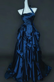 Navy blue evening gown on a mannequin against a dark background