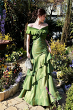 Woman in a green dress standing in a garden
