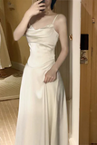Woman wearing a white satin dress in a room.