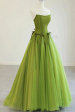 Green evening gown on a mannequin against a white background
