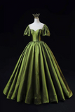 Green evening gown on a mannequin against a black background