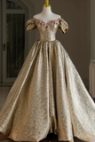 Gold evening gown with floral details on a mannequin against a neutral background