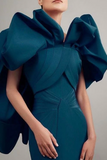 Teal dress with large ruffled shoulders on a neutral background