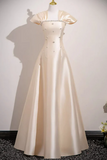 Beige evening gown on a mannequin against a white wall