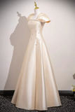 White evening gown on a mannequin against a plain background