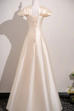 White evening gown on a mannequin against a plain background
