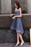 Woman in a blue dress standing against a textured wall.