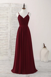 Burgundy evening gown on a mannequin against a white wooden background