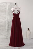 Burgundy evening gown with criss-cross straps on a mannequin against a white background