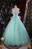 Mint green ball gown on a mannequin against a floral curtain background