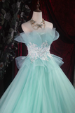 Mint green dress with floral embellishments on a mannequin against a dark background