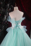 Mint green evening gown on a mannequin against a dark floral and red curtain background