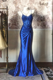 Blue evening gown on a mannequin against a decorative wall.