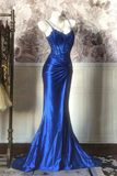 Blue evening gown on a mannequin against a decorative wall.