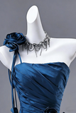 Mannequin wearing a blue strapless dress with a decorative necklace and flower accessory against a gray background