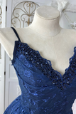 Blue lace dress with beaded details on a mannequin against a decorative background