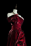 Red evening gown on a mannequin against a black background