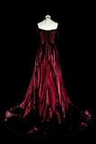 Red evening gown on a mannequin against a black background