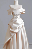 White satin evening gown with a beaded belt on a mannequin against a gray background