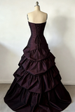 Dark purple gown on a mannequin against a plain background