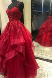 Red evening gown with floral details on a mannequin in a store setting.