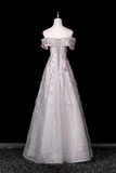 Elegant silver evening gown on a mannequin against a black background