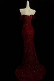 Red evening gown on a mannequin against a black background