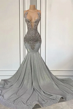 Silver evening gown with intricate detailing on a mannequin against a neutral background