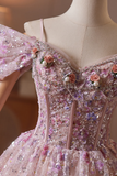 Close-up of a pink evening gown with floral and bead details on a mannequin.
