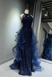 Navy blue evening gown with ruffled layers on a mannequin against a neutral background.