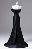 Black evening gown on a mannequin against a gray background